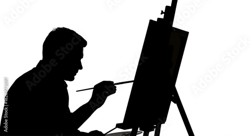Silhouette of a focused artist painting on canvas with precision and passion creating art