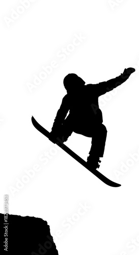 Silhouette of a snowboarder performing a jump off cliff edge on a clear backdrop