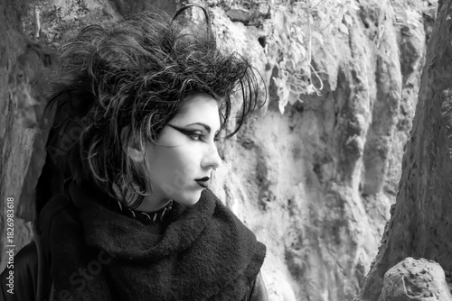 Portrait of Dark gothic fashion youg woman with black makeup, black lipstick and nose piercing. Italian beautiful brunette girl. Dark lady. Dark girl. Trad goth girl. Black and white photo. Close-up