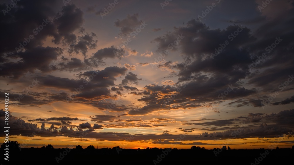 Obraz premium Cloudy sky at sunset or sunrise with vibrant colors and scattered clouds. Nature and sky scene. The beauty of a cloudy sky during twilight.