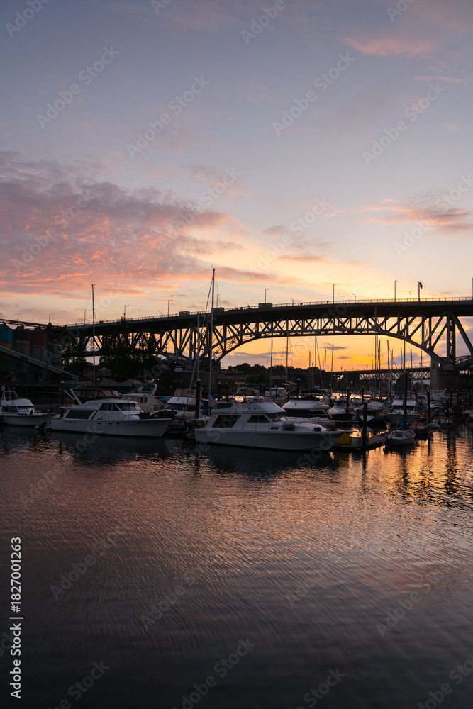 Fototapeta premium Vancouver, Canada – May 23, 2021 - Granville Bridge over False Creek Yacht Club.The Granville Bridge arches over False Creek at sunset. Boats tied up at the False Creek Yachtclub docks. 