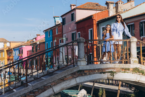 Mother and daughter enjoying ice cream on Burano bridge