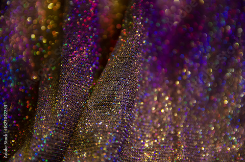 Multicolor shiny background. Fabric screensaver. Festive decoration. Light and bokeh.