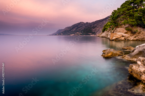 Fototapeta Naklejka Na Ścianę i Meble -  Croatia, Dalmatia, the Adriatic coast at sunrise, with the Biokovo Mountains and forests in the background. The village of Brela is a summer resort on the Makarska Riviera.