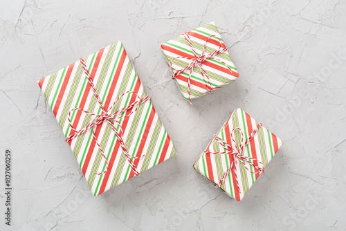 Striped Christmas gift boxes on concrete background, top view