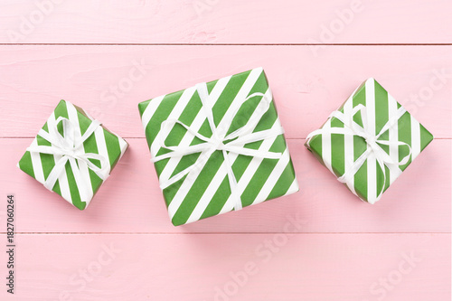 Striped Christmas gift boxes on wooden background, top view