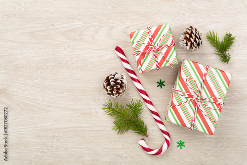 Striped Christmas gift boxes on wooden background, top view