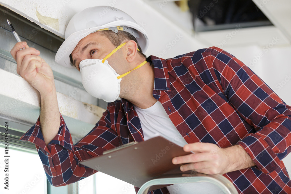 Obraz premium inspector wearing mask while assessing property