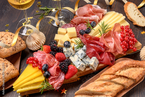 Party charcuterie board italian food antipasti prosciutto ham, salami and cheese appetizers served in the shape of a Christmas tree. party food for New Year's Eve, Christmas or birthday