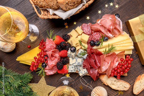 Party charcuterie board italian food antipasti prosciutto ham, salami and cheese appetizers served in the shape of a Christmas tree. party food for New Year's Eve, Christmas or birthday