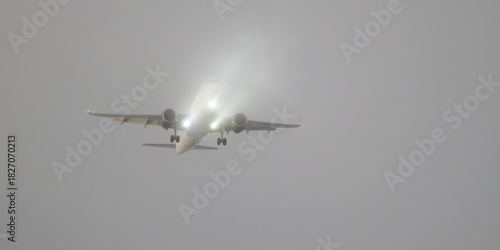Commercial passenger aircraft descending through cloud layer on fianl approach to landing