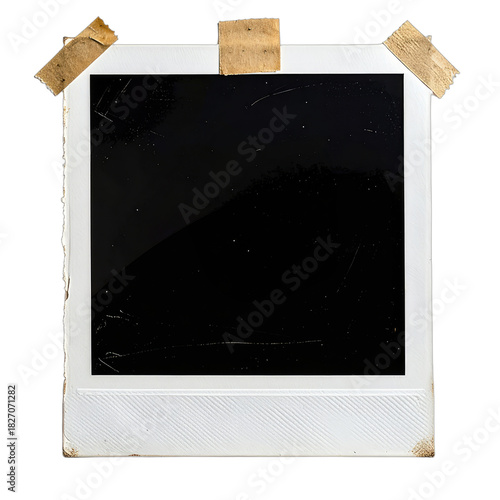 A vintage instant film frame with a dark, blank center, secured by aged tape.