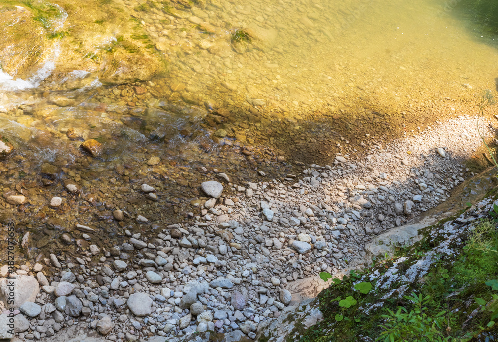 Fototapeta premium a mountain river with a rapid flow and an unusual stone bed and waterfalls in the summer