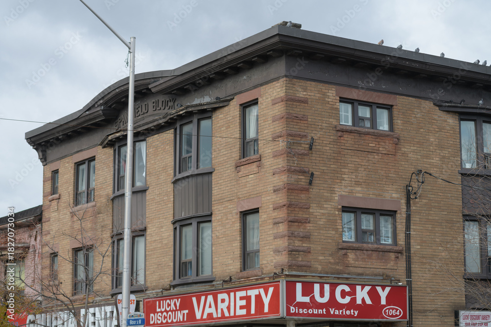 Fototapeta premium historic apartment block and sign of Lucky Discount Variety Store located at 1064 Bloor St W, Toronto