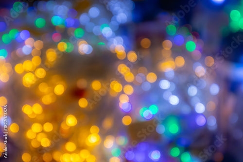 Colorful bokeh lights create a festive atmosphere, blending warm yellows and cool blues, evoking a sense of celebration and joy during holiday gatherings and special occasions