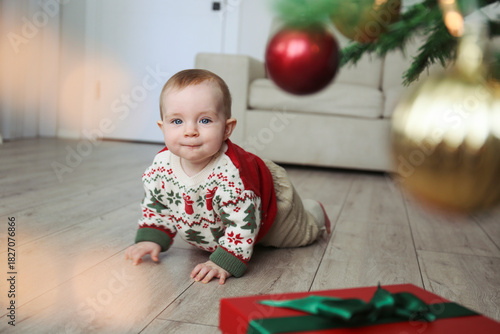 Baby crawling towards a christmas present. Copy space, background.