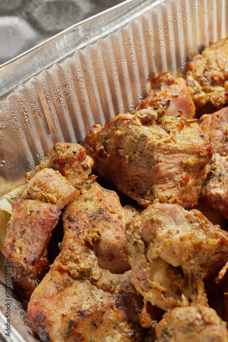 Close-up of grilled shashlik kebab pieces in a foil tray