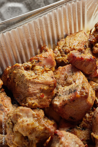 Close-up of grilled shashlik kebab pieces in a foil tray