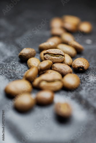 Close-up of a group of roasted coffee beans on a black baking tray background