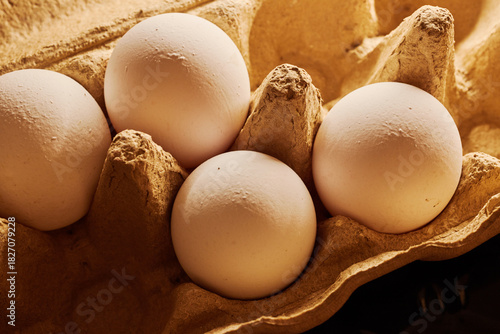 Close-up of several chicken eggs in a paper egg carton