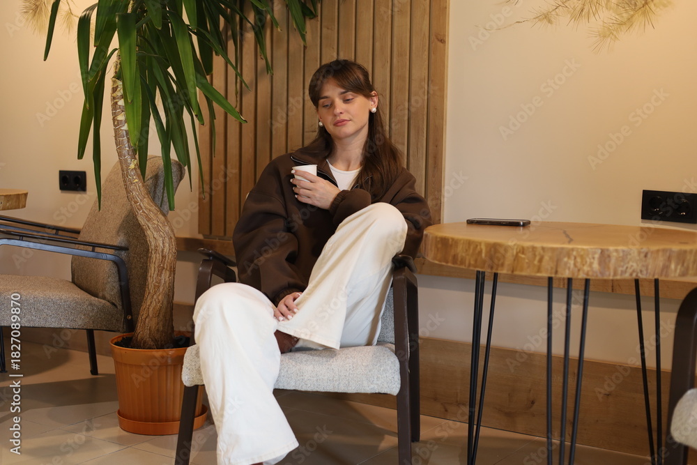 Obraz premium Woman enjoying a coffee break in a modern lounge area