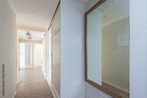 Bright modern hallway interior with large wall mirror