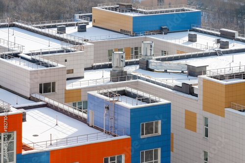 Snow-covered modern rooftop with ventilation systems aerial view