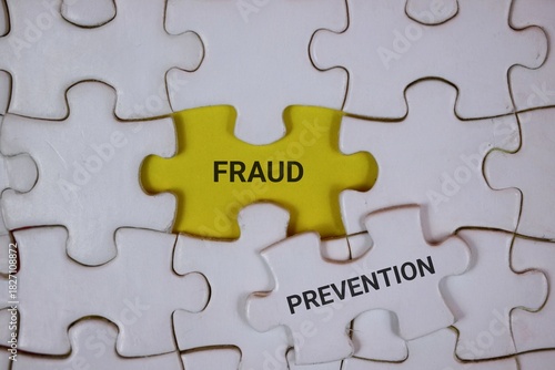 white puzzle pieces with an yellow center piece labeled FRAUD and an adjacent white piece reading PREVENTION, symbolizing awareness, detection, and proactive safeguards in business security.