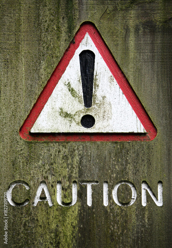 Caution warning sign carved into wood