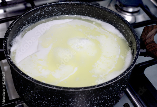 Bild auf Leinwand Milk curdling in pot on stove during homemade cheese making process