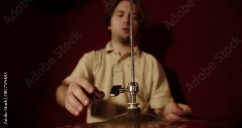 Professional drummer setting up hi hat cymbal in recording studio