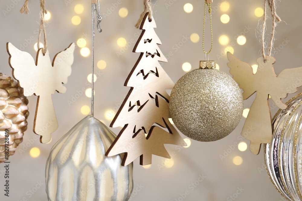 Obraz premium Beautiful Christmas decor hanging on string against blurred lights, closeup