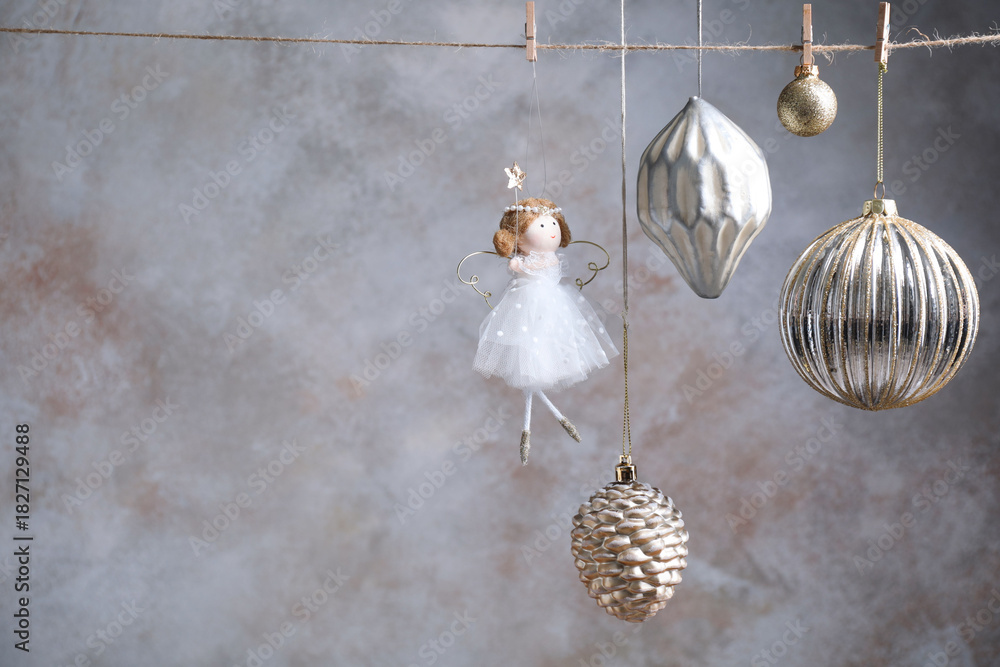 Naklejka premium Beautiful Christmas decor hanging on string near light grey wall. Space for text