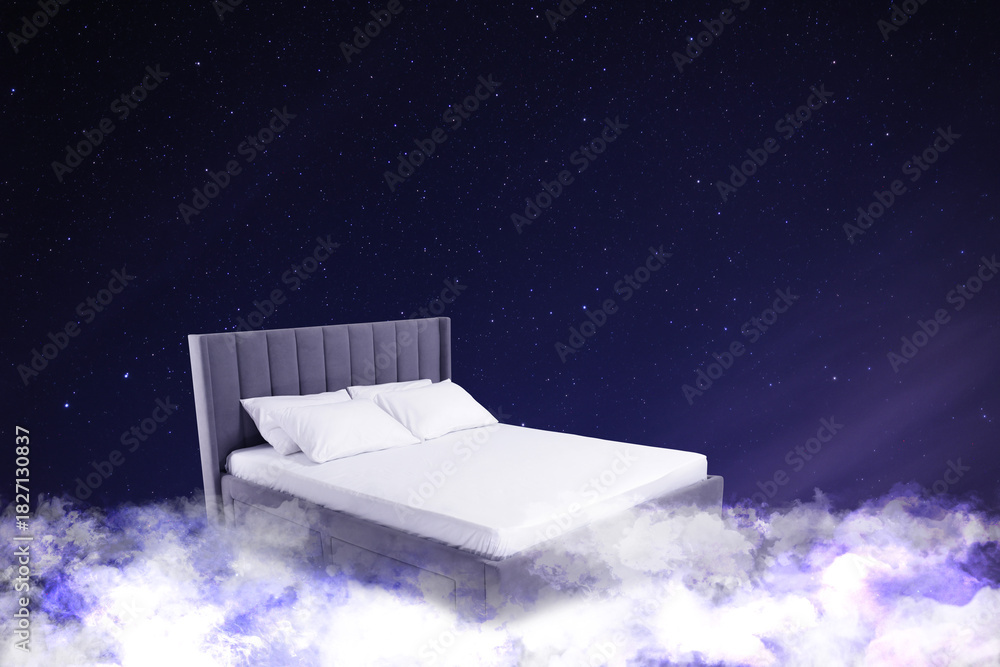 Fototapeta premium Large bed on fluffy clouds in starry night sky