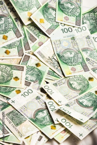 Wallpaper Mural A vibrant spread of Polish 100-zloty banknotes arranged in a scattered pattern, showcasing detailed security elements, rich green tones, and historical portrait artwork on display. Torontodigital.ca