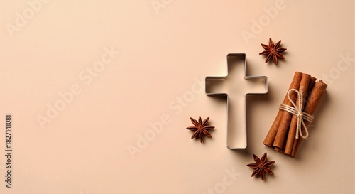 Christian cross cookie cutter with cinnamon and star anise spices. Holiday baking flat lay for Christmas or Easter. Religious background with copy space