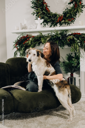 Woman cuddling dog during christmas holidays