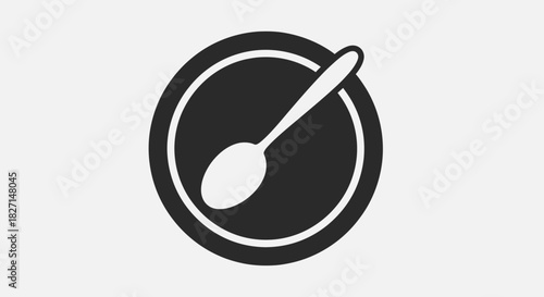 Simple black spoon resting on a dark plate ready for dining experience.