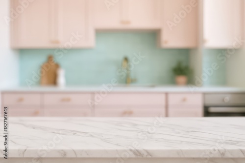 Kitchen with a white countertop and pink cabinets. The countertop is a marble slab with a green wall behind it