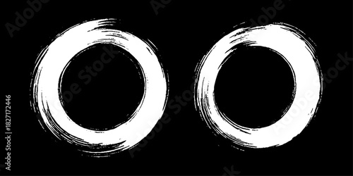 Two bold black ink circles painted with dynamic brush strokes, minimalist Japanese sumi-e style, clean background.