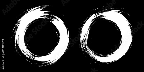 Two bold black ink circles painted with dynamic brush strokes, minimalist Japanese sumi-e style, clean background.