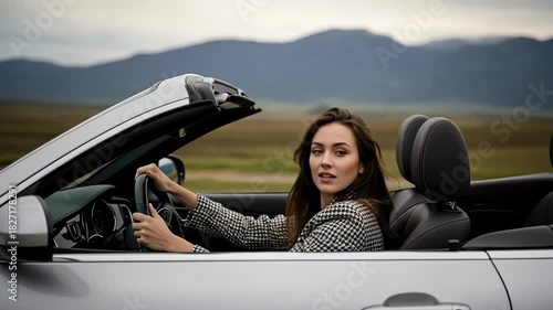 Woman drives a convertible with the top down on an open road, enjoying the freedom of the journey. Scenic drive and carefree lifestyle