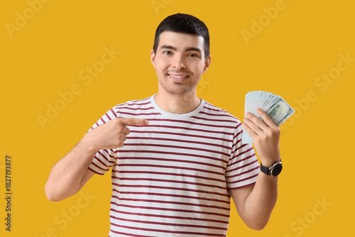 Young man pointing at dolla...