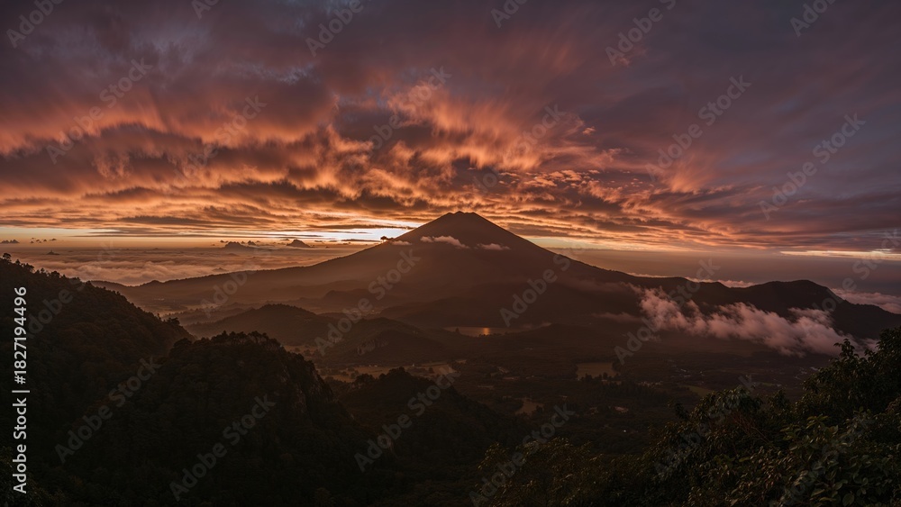 Naklejka premium Sunset over the mountain with dramatic clouds and misty valleys. Nature and landscape, scenery, volcanic formation. The beauty of the natural world.