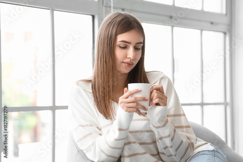 Young woman with cup of hot...