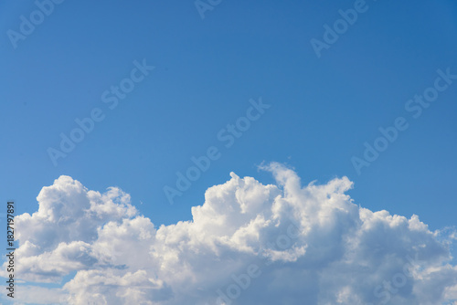 Bodies of cumulus clear white clouds tower in bright blue sky background