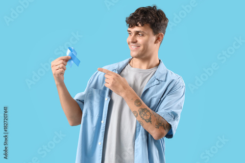 Young man pointing at blue ...