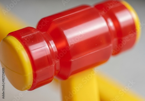 Vibrant plastic hammer toy closeup, featuring playful red and yellow colors