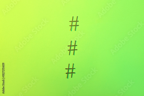 Hashtags made of paper on g...