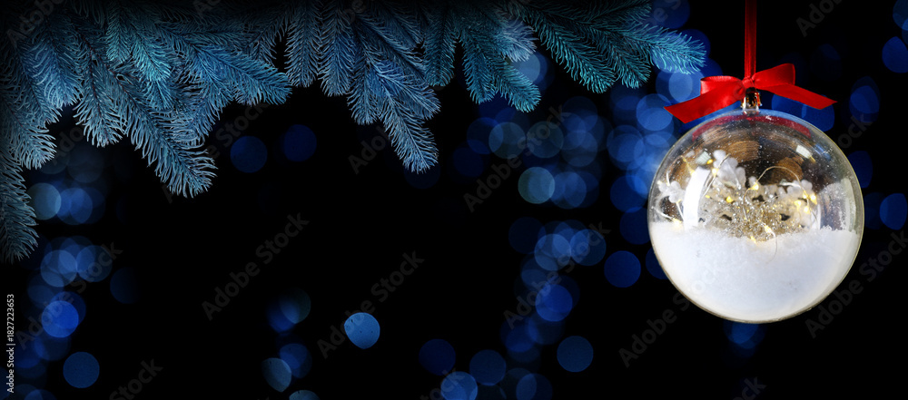 Fototapeta premium Christmas ball and fir tree branches against black background, banner design. Transparent festive ornament and bokeh lights on greeting card